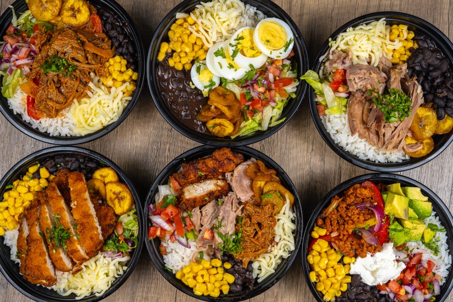 Six rice bowls with chicken, beef and vegetables seen from above
