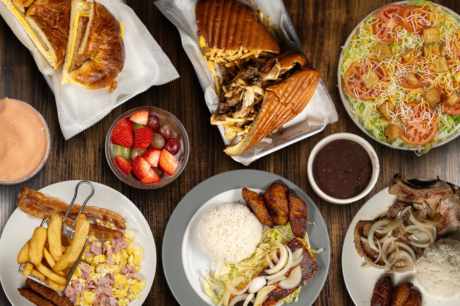Café table with sandwiches, salad and fries seen from above