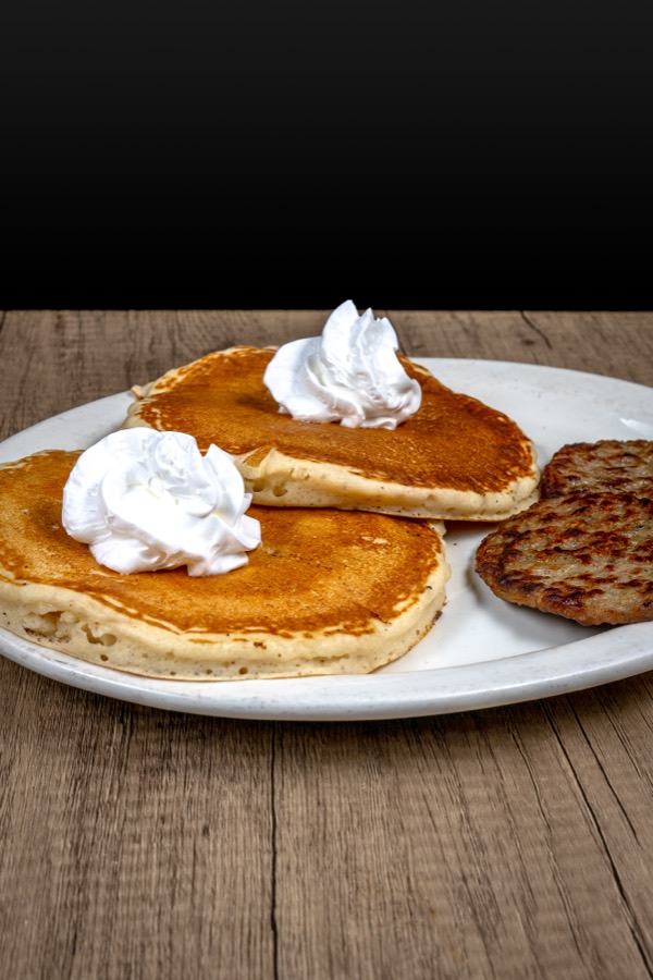 Pancakes with whipped cream and sausage