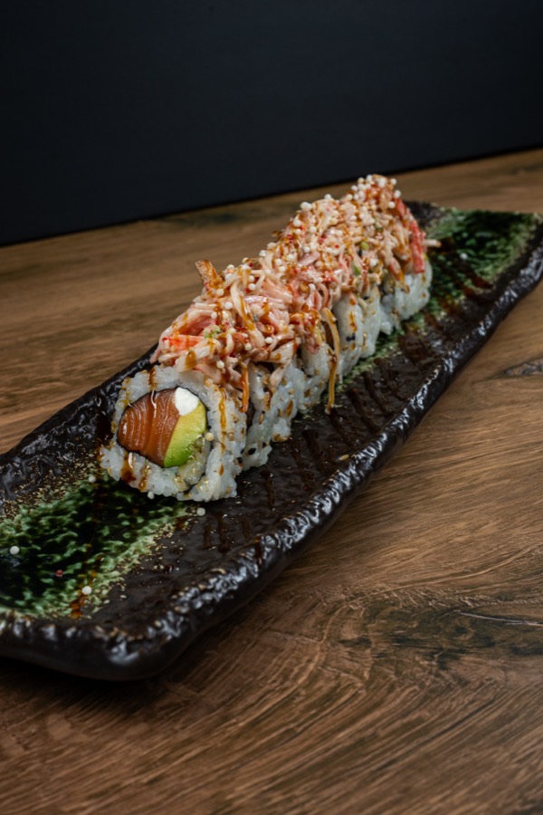 Salmon sushi roll on a black stone plate