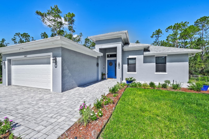 Modern gray home with a paver driveway