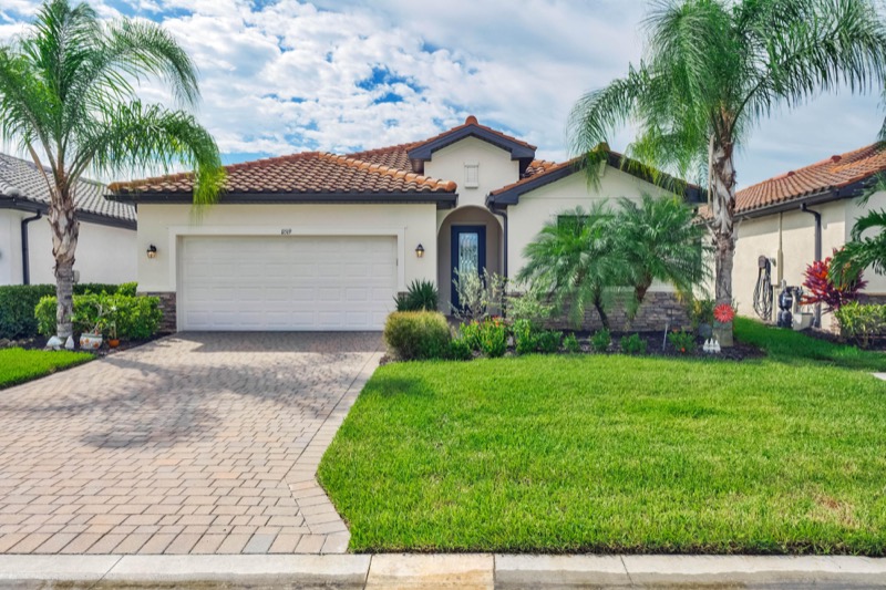 Front of a single-story home with palm trees